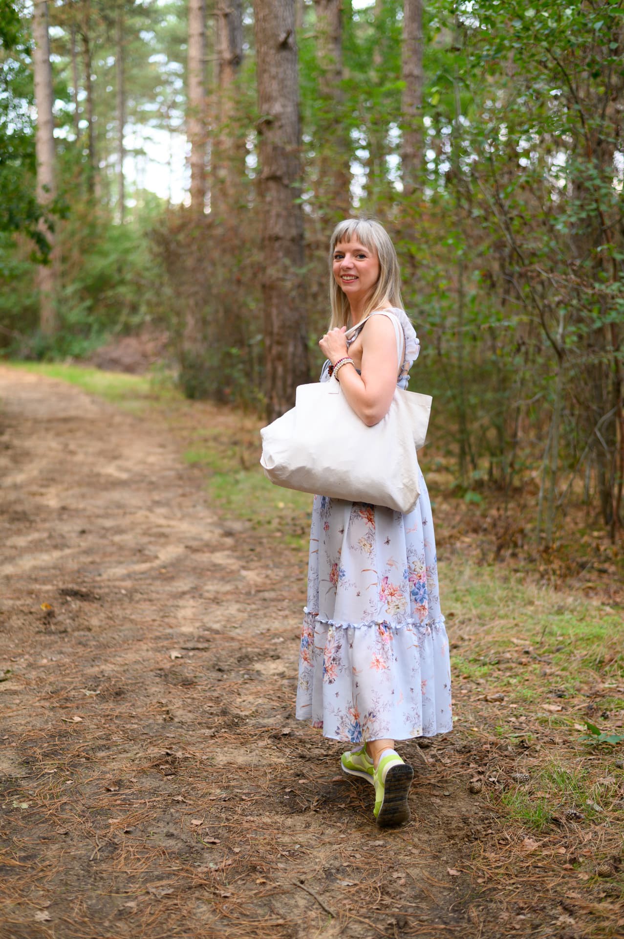 Ethel Eerdekens loopt met een tas het bos in, klaar voor een kennismakingswandeling
